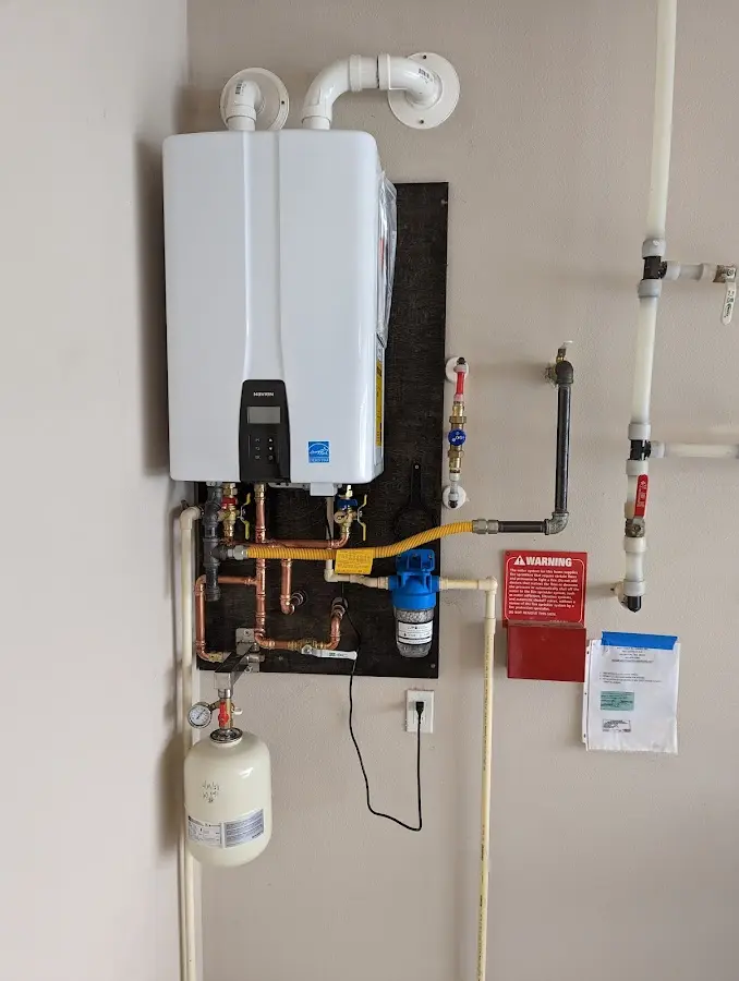 Professional plumber installing copper piping in a Elbridge home